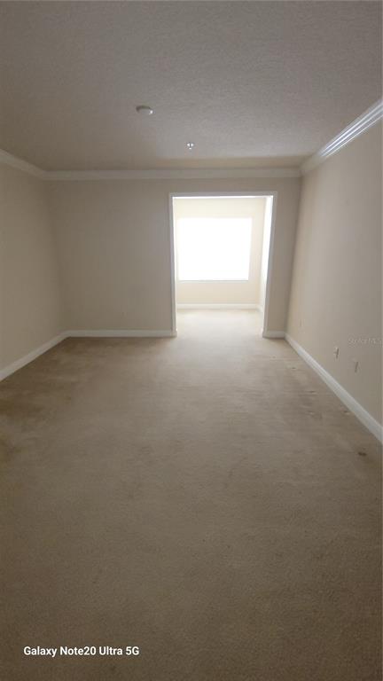 A carpeted room leads into a smaller, brightly lit alcove with a window — 430 SOUTHERN PECAN CIRCLE UNIT 203, WINTER GARDEN, FL