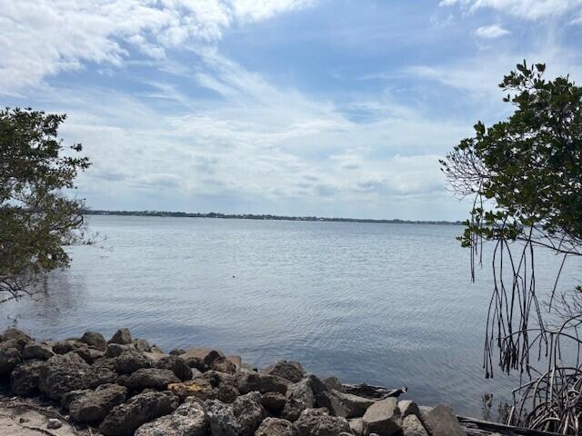 A view of a calm body of water framed by trees and a rocky shoreline — 0 Aqua Ra Drive, Jensen Beach FL 34957, JENSEN BEACH, FL