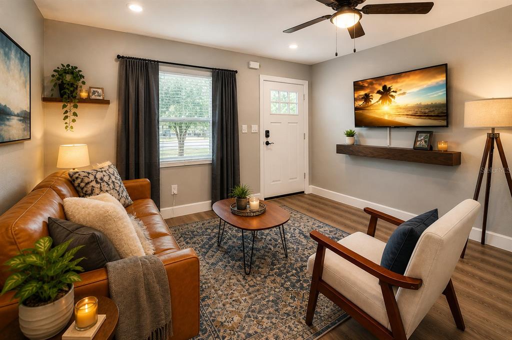 A living room features a leather sofa, an armchair, a television, and a front door — 1000 8TH AVENUE SW, LARGO, FL