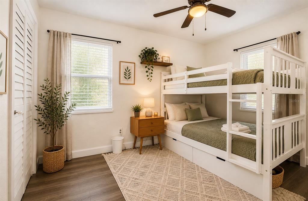 A bedroom features a white bunk bed, a wooden nightstand, and a patterned area rug — 1000 8TH AVENUE SW, LARGO, FL
