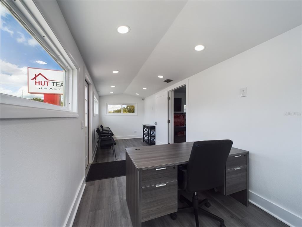 An office space features a gray desk, chairs, recessed lighting, and wood-look flooring — 334 1ST STREET S, WINTER HAVEN, FL