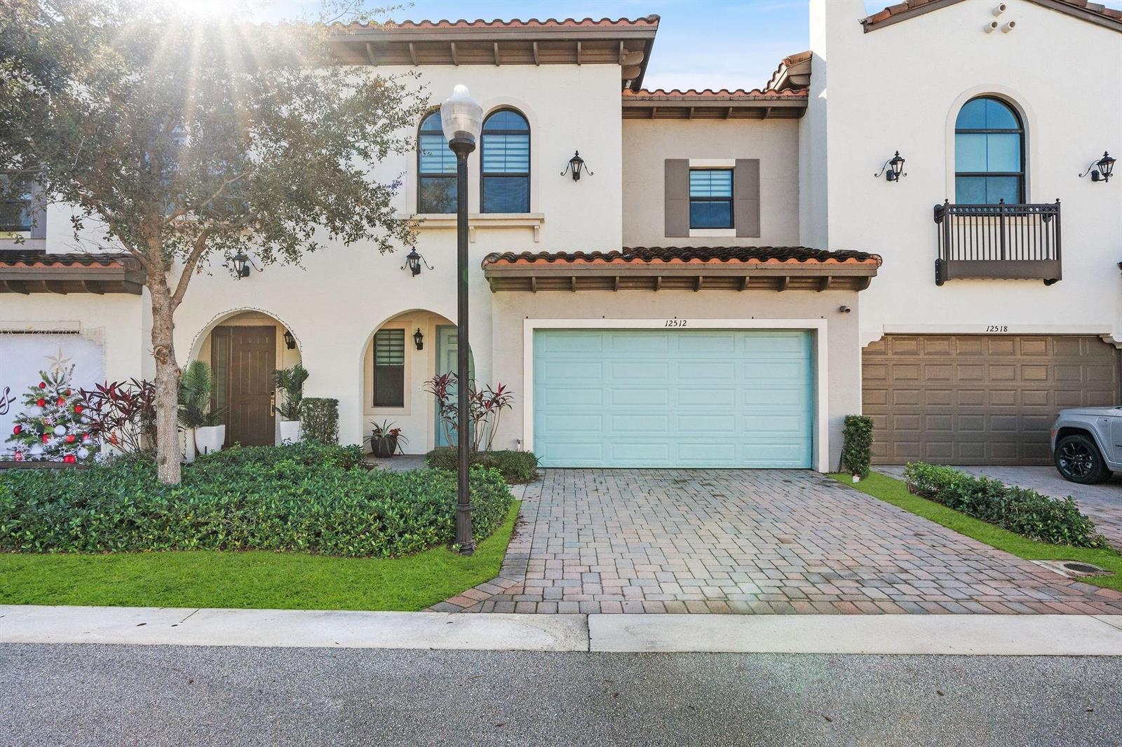 A two-story townhouse exterior features a light blue garage door and a paved driveway — 12512 NW 32 Manor # 3, Sunrise FL 33323, SUNRISE, FL