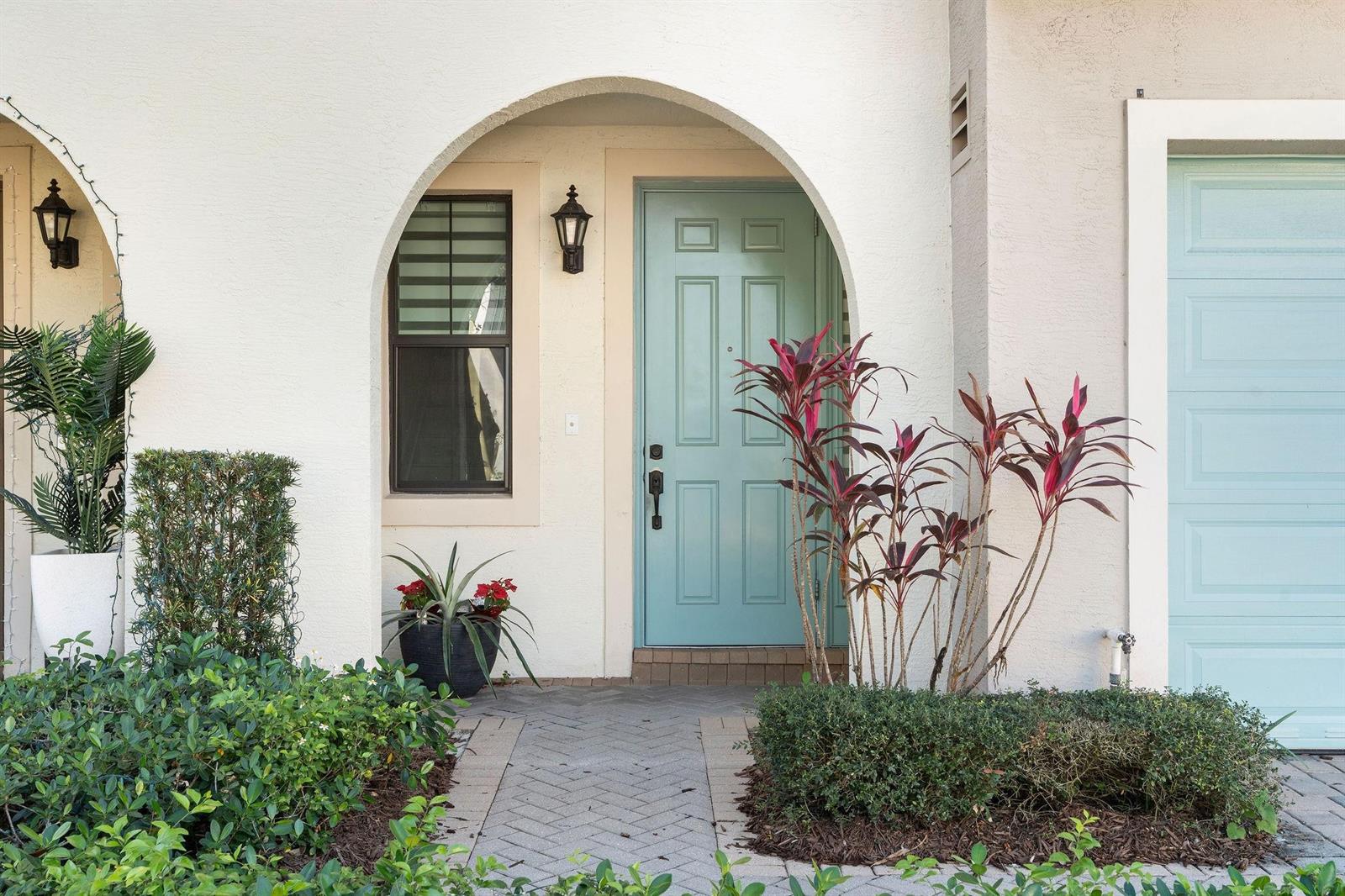 A light blue front door sits within a stucco archway next to a garage door — 12512 NW 32 Manor # 3, Sunrise FL 33323, SUNRISE, FL