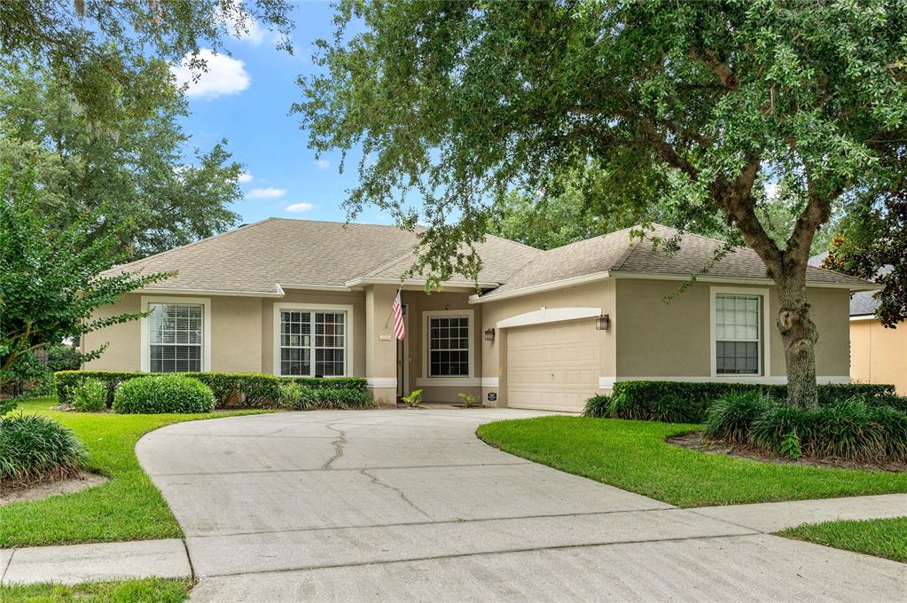 A single-story house with a beige exterior, a two-car garage, and a concrete driveway — 1500 LUCKY PENNIE WAY, APOPKA, FL