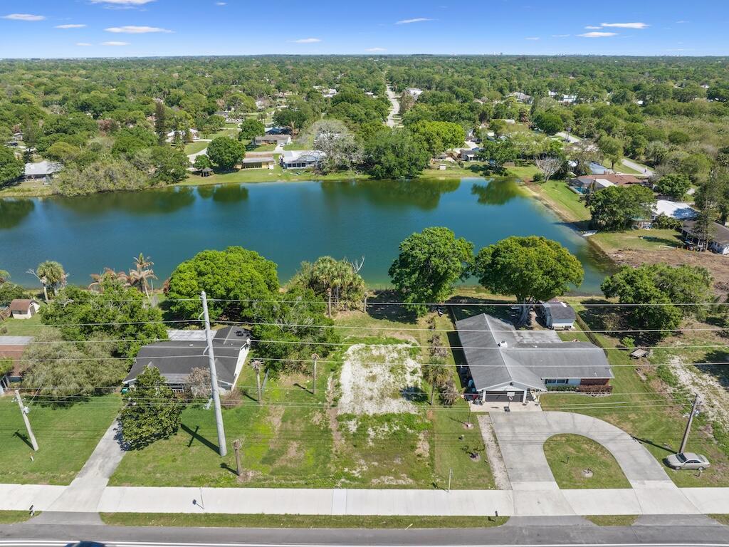 An aerial view shows a vacant lot situated between two houses facing a lake — 6208 Emerson Avenue, Fort Pierce FL 34951, FORT PIERCE, FL