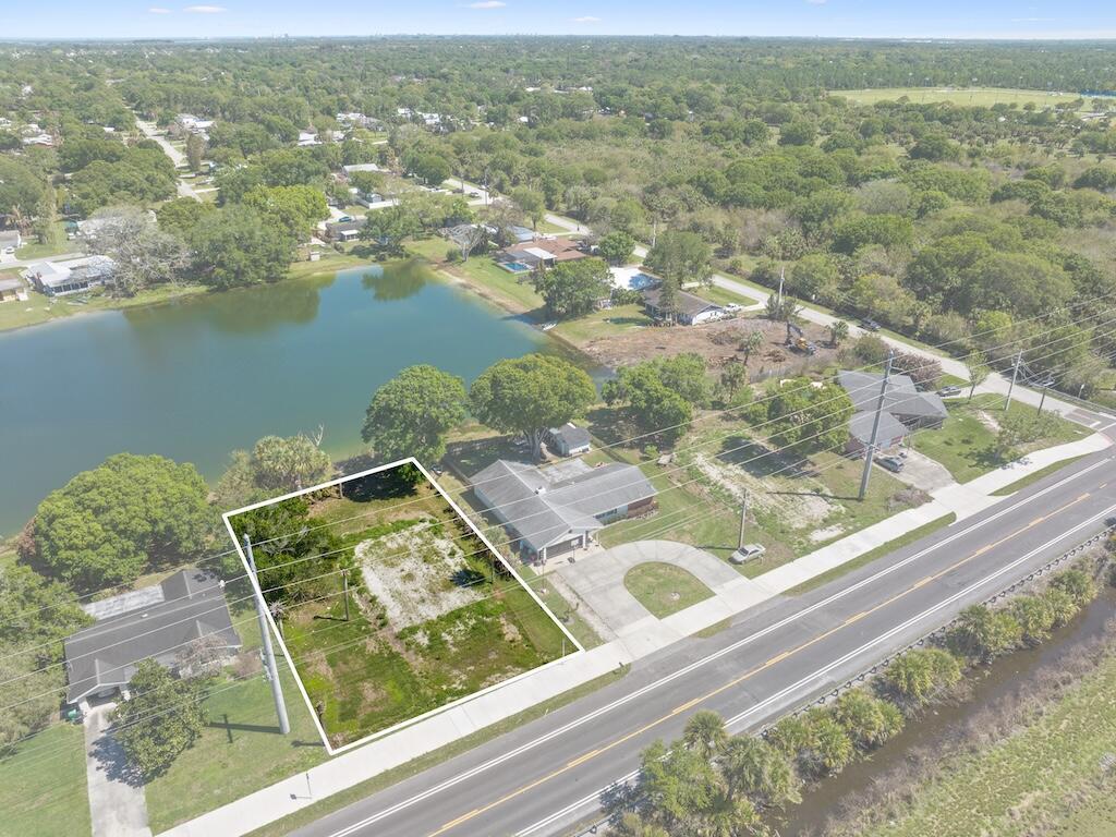 An aerial view shows a vacant, rectangular lot next to a house by a lake — 6208 Emerson Avenue, Fort Pierce FL 34951, FORT PIERCE, FL