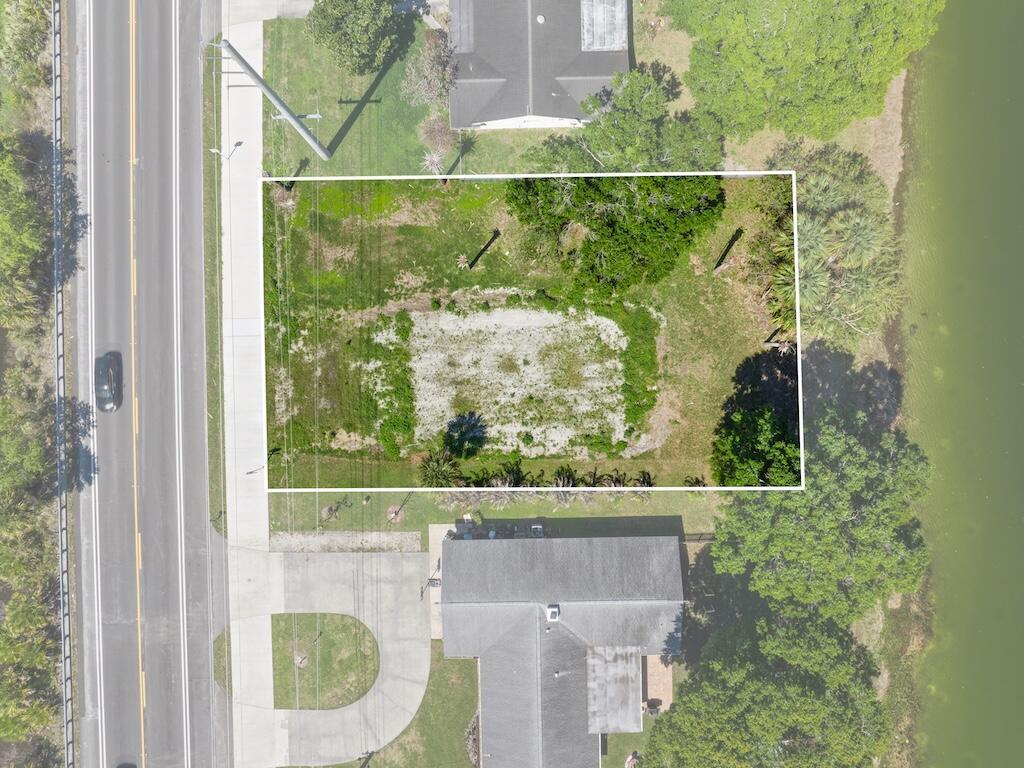 An aerial view shows a rectangular vacant lot situated between a road and a lake — 6208 Emerson Avenue, Fort Pierce FL 34951, FORT PIERCE, FL