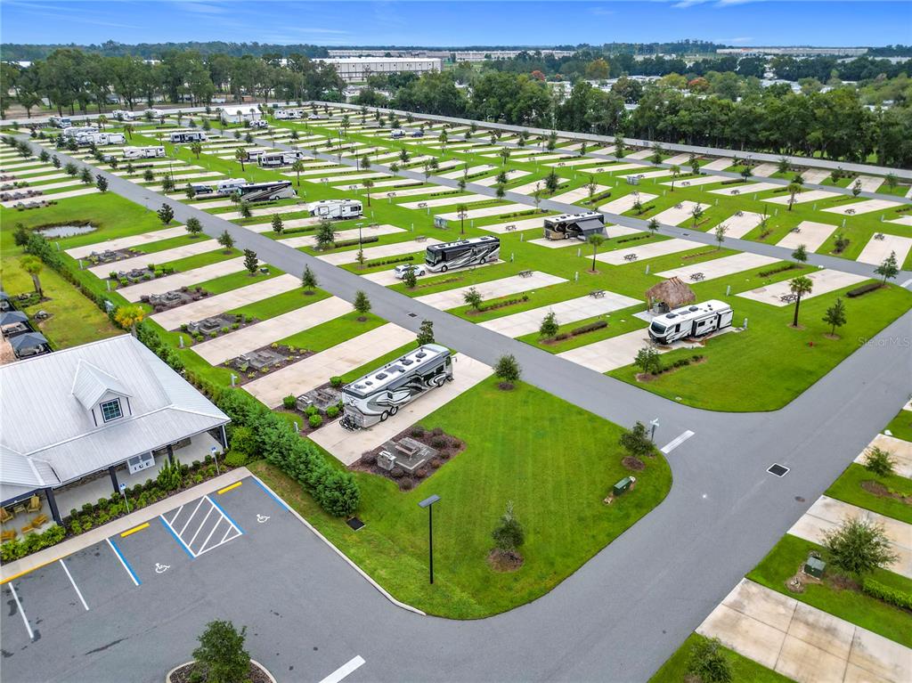 An aerial view of an RV park featuring paved parking pads, grass lawns, and parked vehicles — 2979 NW 41ST CIRCLE, OCALA, FL