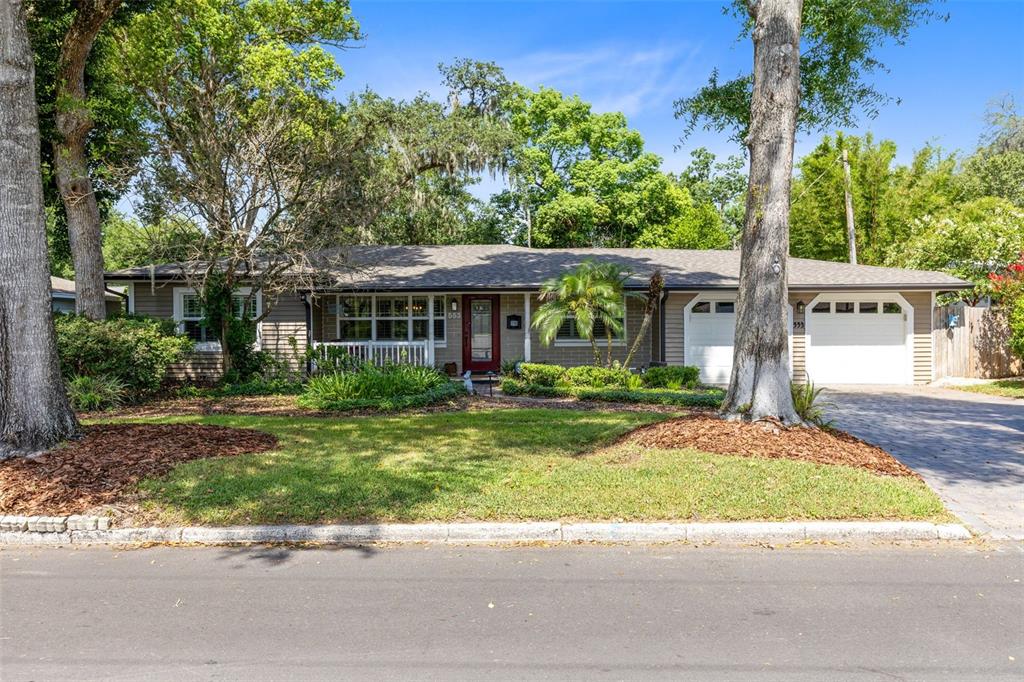 A single-story house with a brown exterior, a red front door, and a two-car garage — 553 ARAPAHO TRAIL, MAITLAND, FL