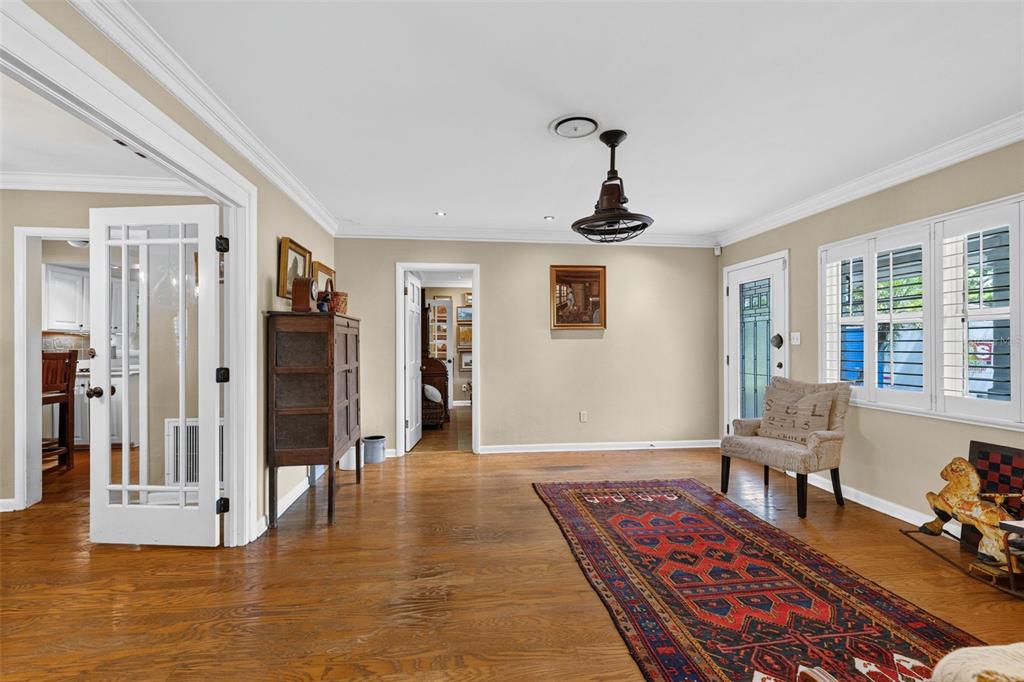 A living room with hardwood floors, a patterned rug, a ceiling fan, and white trim — 553 ARAPAHO TRAIL, MAITLAND, FL