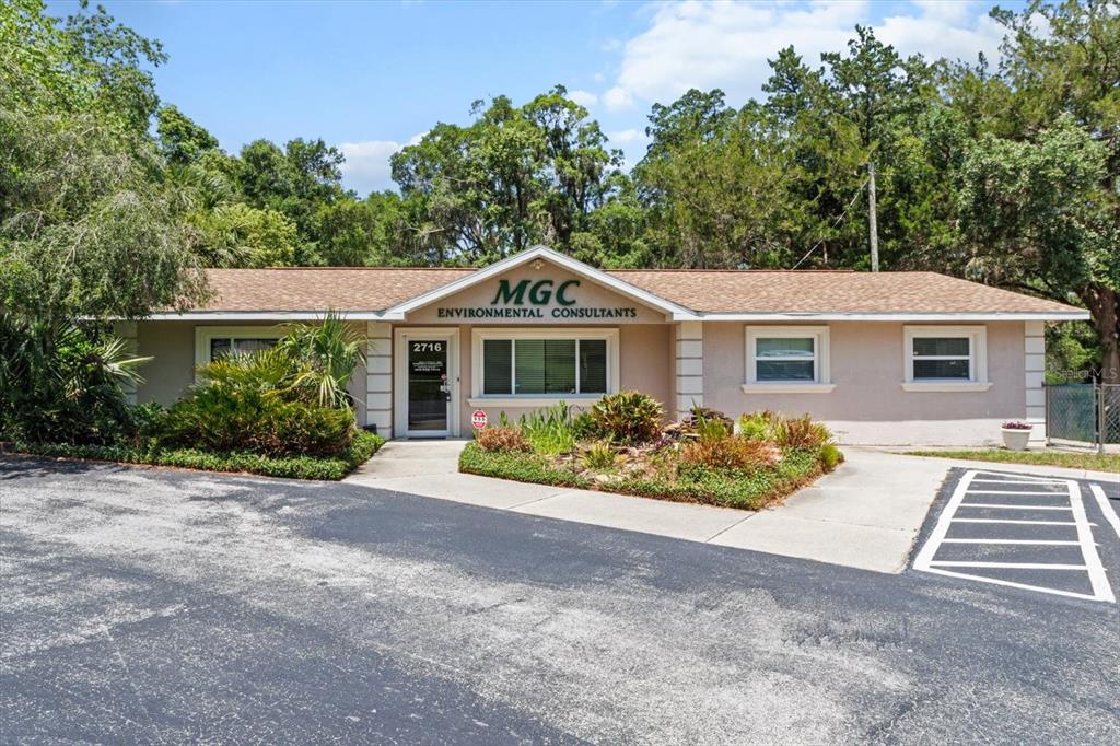A single-story commercial building with a tan exterior, brown roof, and a paved parking lot — 2716 S LECANTO HIGHWAY, LECANTO, FL