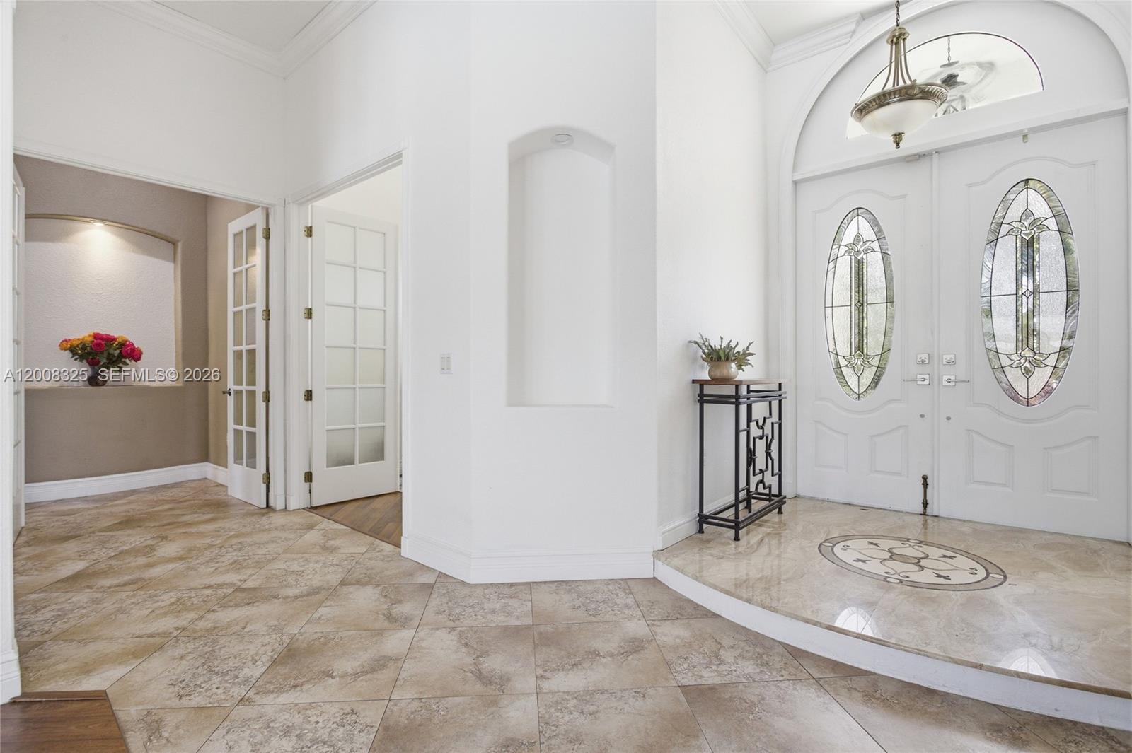 A bright foyer features a raised marble entryway, double glass-paneled doors, and tiled flooring — 20401 SW 48th Pl, Southwest Ranches FL 33332, SOUTHWEST RANCHES, FL