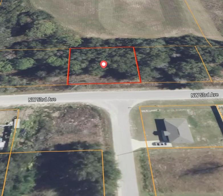This aerial map shows a vacant, wooded residential lot outlined in red along a paved road — 0 NW 53RD AVENUE, OCALA, FL