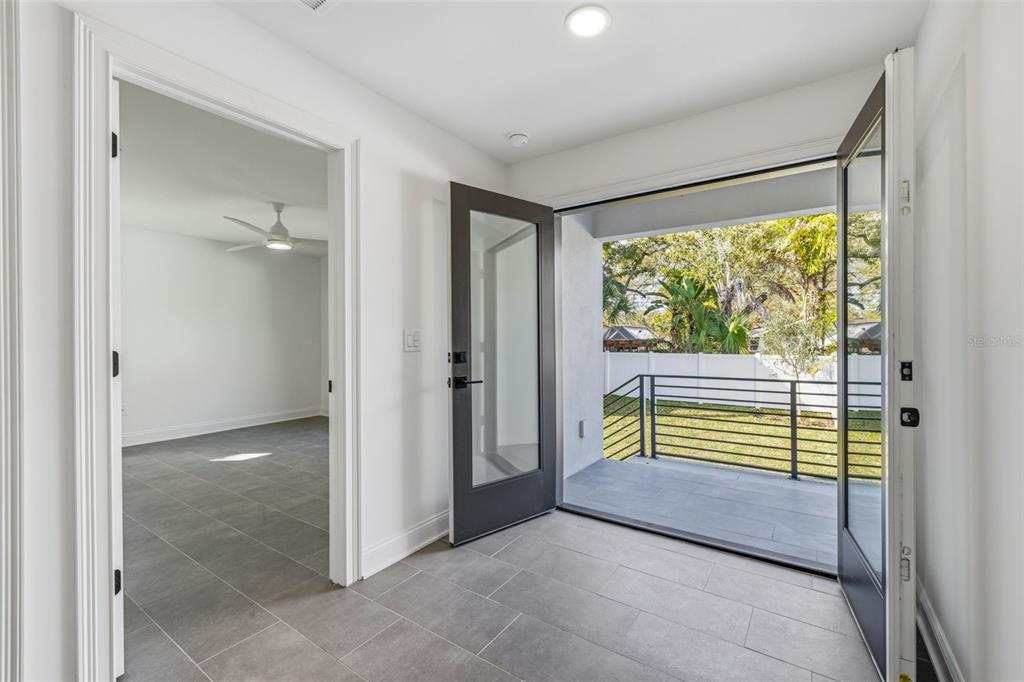 An interior view shows a tiled room with a doorway leading to a covered balcony — 4509 W NORTH A STREET UNIT 2, TAMPA, FL