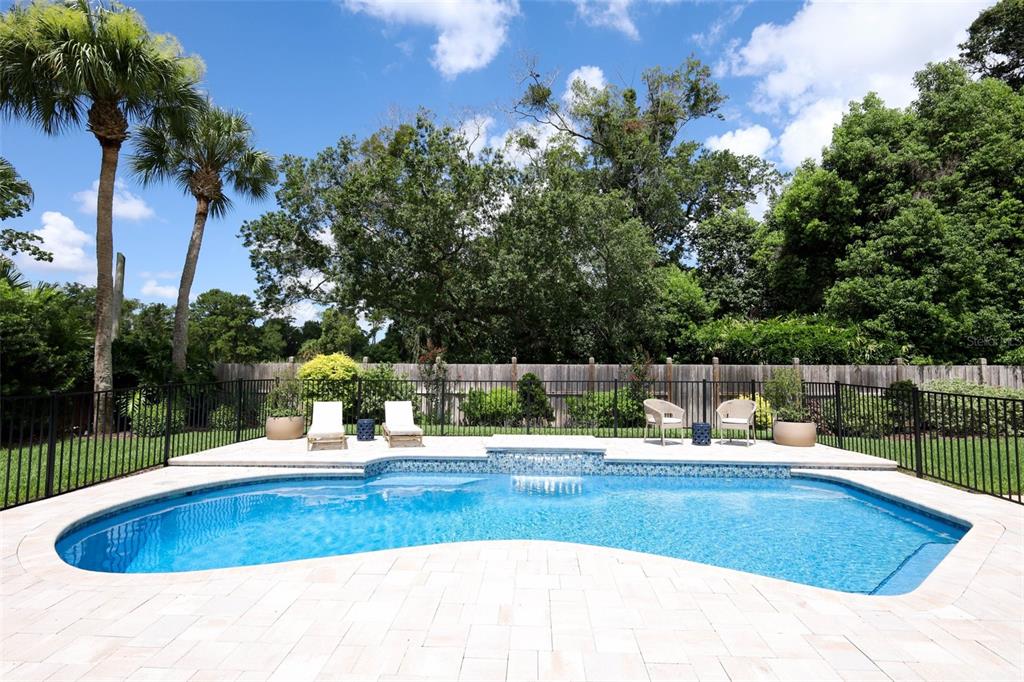 A backyard swimming pool with a water feature, lounge chairs, and a wooden fence — 280 W SPRING LAKE DRIVE, ALTAMONTE SPRINGS, FL