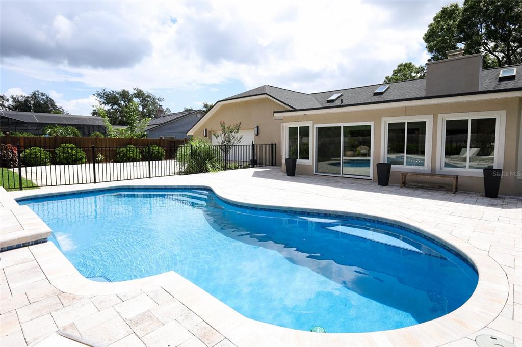 A backyard features a swimming pool with a paver deck and a tan house exterior — 280 W SPRING LAKE DRIVE, ALTAMONTE SPRINGS, FL