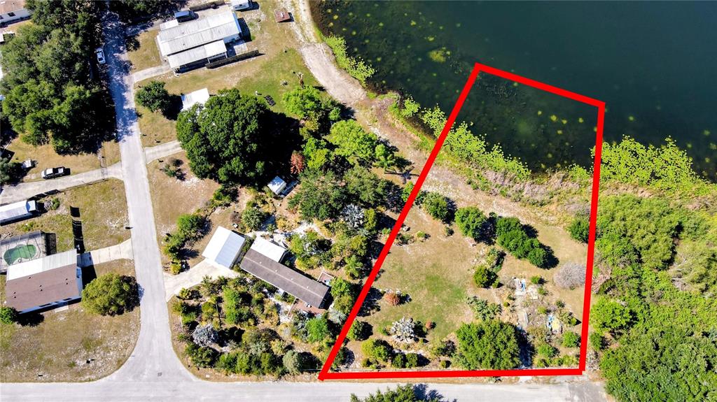 An aerial view shows a residential lot outlined in red bordering a lake — 1100 PENINSULAR DRIVE, LAKE WALES, FL
