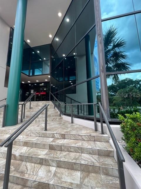 A set of tiled stairs leads to the glass-walled entrance of a modern commercial building — 1118 S ORANGE AVENUE UNIT 104, ORLANDO, FL