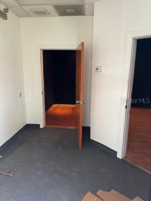 An interior view shows a carpeted room with two open doorways leading to wood-floored spaces — 1118 S ORANGE AVENUE UNIT 104, ORLANDO, FL