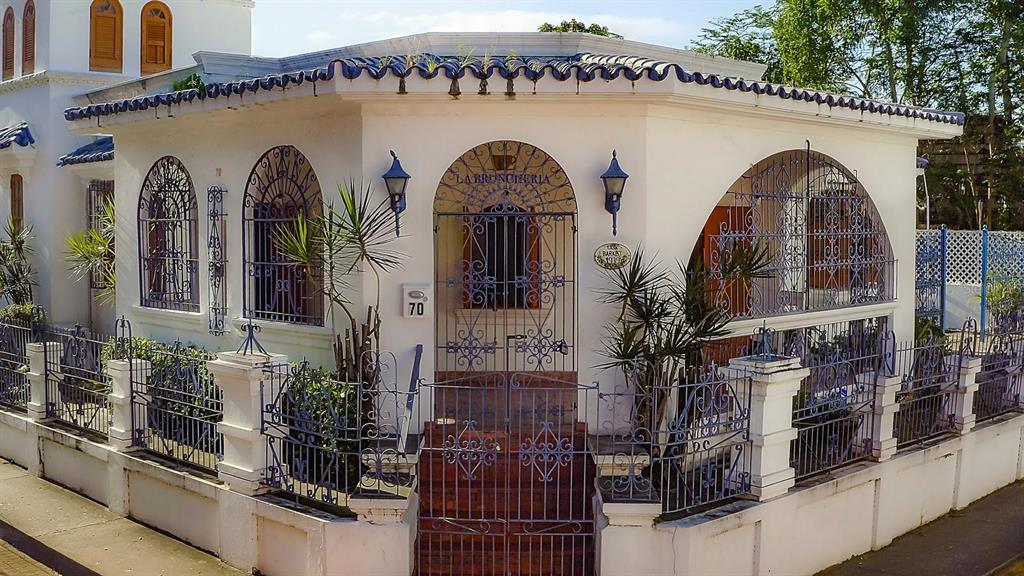 An exterior view of a white building with blue roof tiles and ornate metal fencing — 70 Calle DEL BOSQUE, MAYAGUEZ, PR