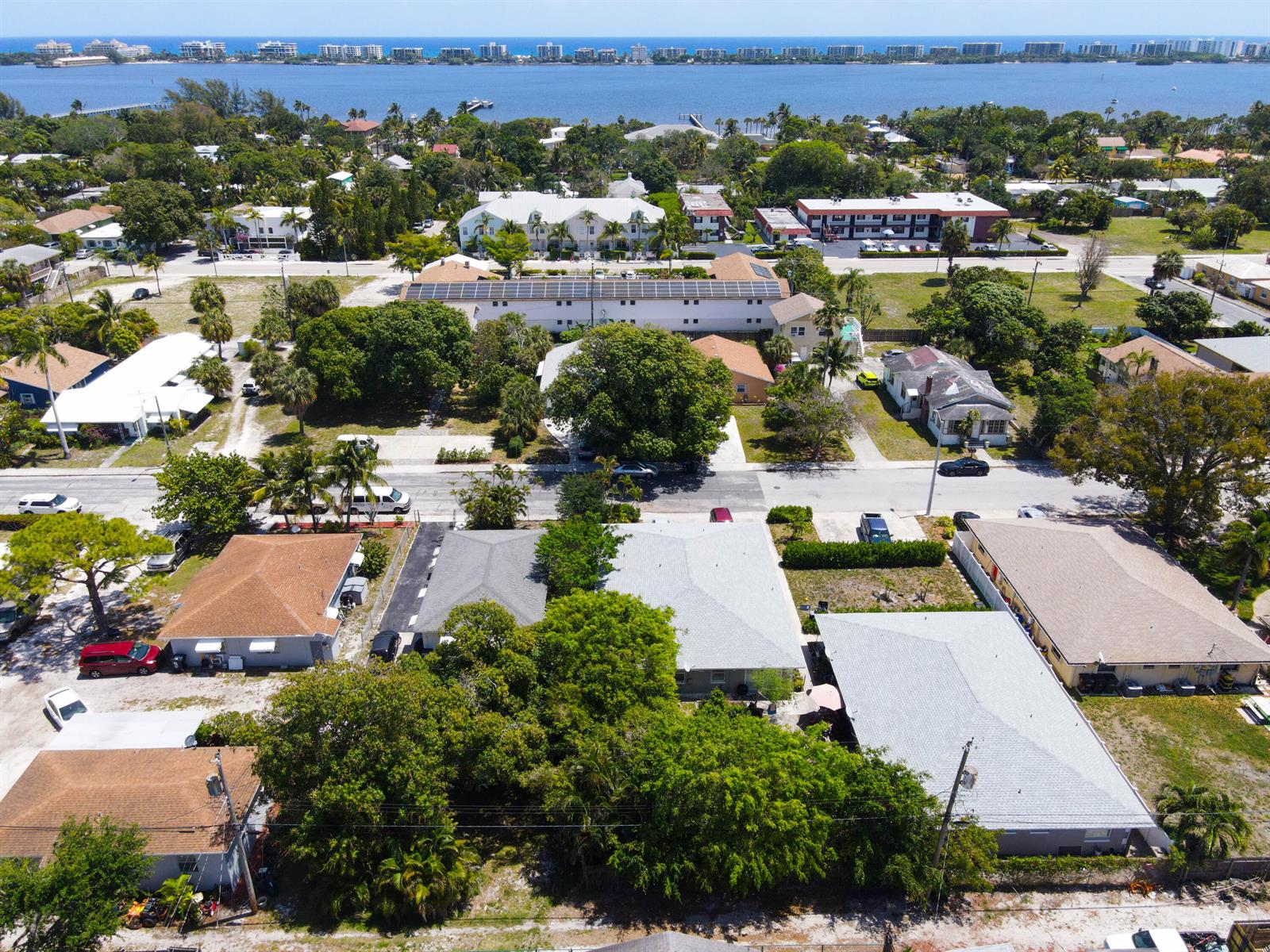 An aerial view shows a residential neighborhood with houses, trees, and a distant waterfront — 909 S N Street, FL 33460, FL