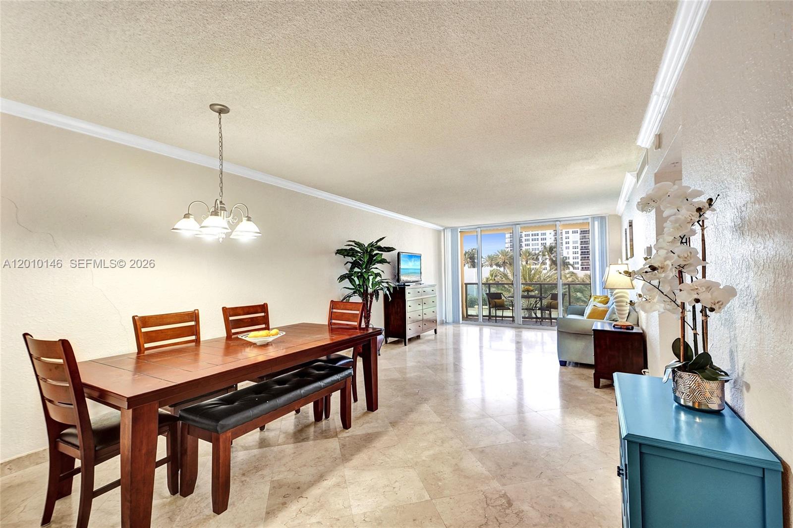 A dining area and living space feature tile floors, a wooden table, and balcony access — 2501 S Ocean Dr # 414, Hollywood FL 33019, HOLLYWOOD, FL