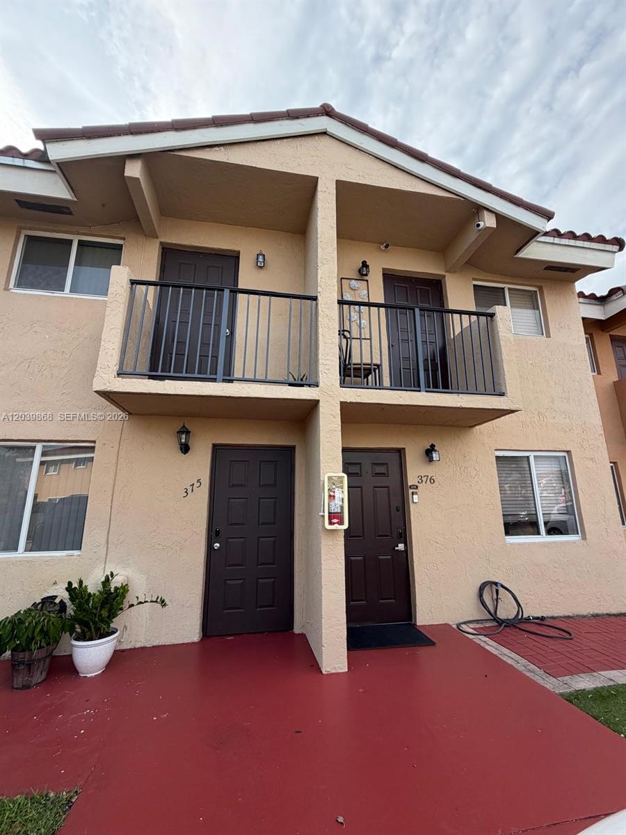 A two-story stucco building features two front doors, two balconies, and a red patio — 541 NW 82nd Ct # 375, Miami FL 33126, MIAMI, FL