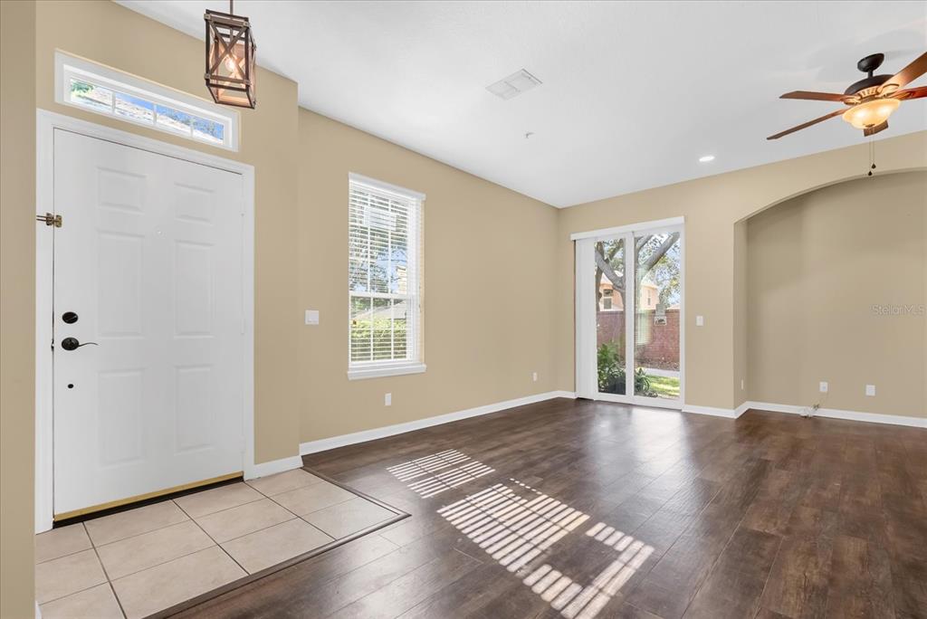 An entryway with tile flooring leads into a living area with wood-look floors and doors — 910 ASHWORTH OVERLOOK DRIVE UNIT A, APOPKA, FL
