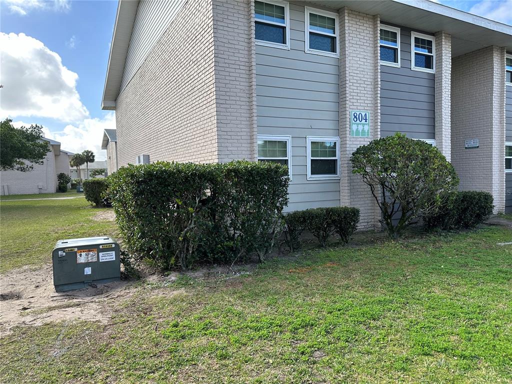 A two-story building with light brick and gray siding features a green address sign — 804 SKY LAKE CIRCLE UNIT B, ORLANDO, FL