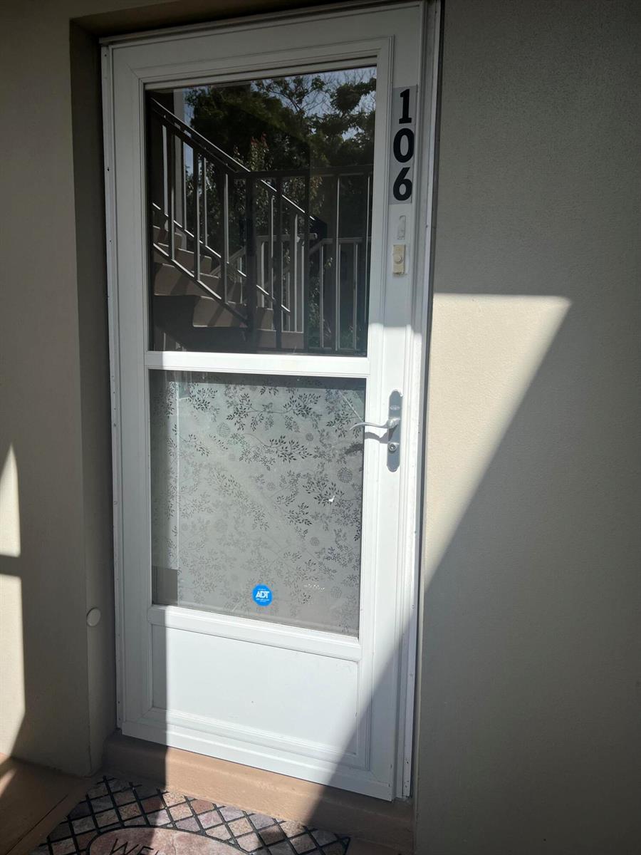 A white storm door with a decorative frosted glass panel and house number 106 — 25 Lake Vista Trail # 106, FL 34952, FL
