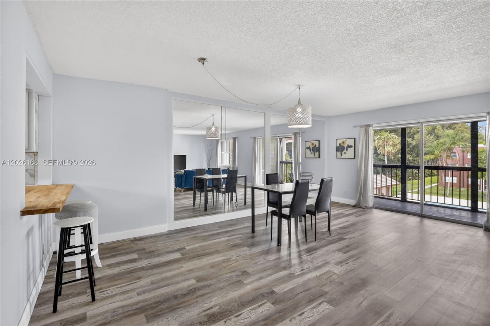 A dining area features a mirrored wall, a modern pendant light, and wood-look flooring — 7020 Nova Dr # 308D, Davie FL 33317, DAVIE, FL