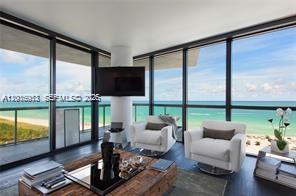A living room with floor-to-ceiling windows overlooking the ocean and two white armchairs — 101 20th St # 1907, Miami Beach FL 33139, MIAMI BEACH, FL