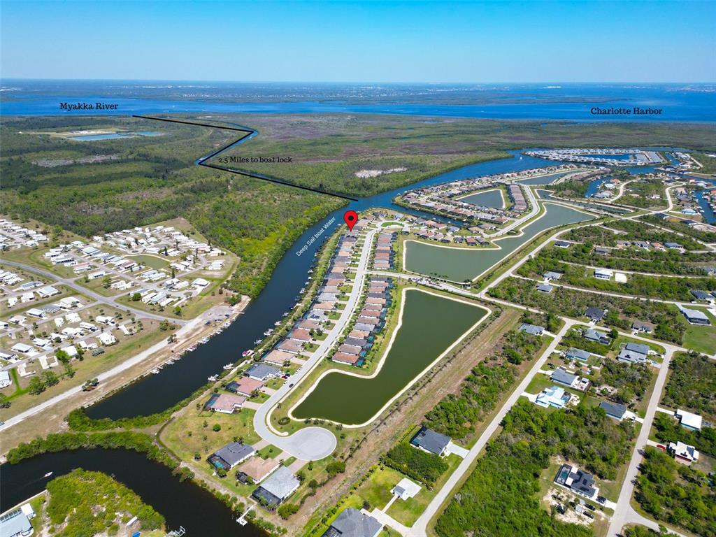 An aerial view shows a residential neighborhood with a canal leading toward the Myakka River — 14500 PONCE DE LEON TRAIL, PORT CHARLOTTE, FL