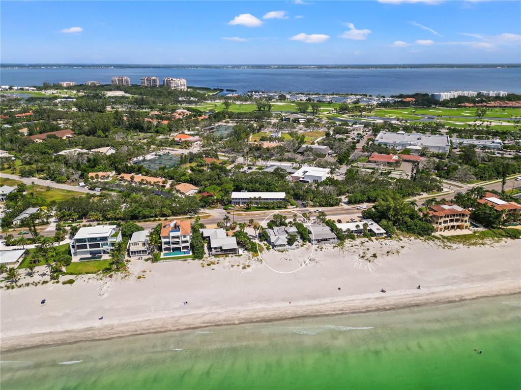 An aerial view shows a beachfront house circled among other coastal properties along the shore — 2823 GULF OF MEXICO DRIVE, LONGBOAT KEY, FL