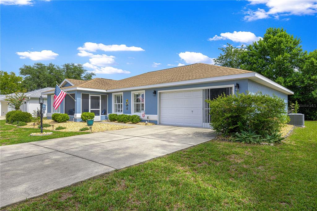 A light blue single-story house with a white garage door and a screened-in front porch — 6091 SW 84TH PLACE ROAD, OCALA, FL