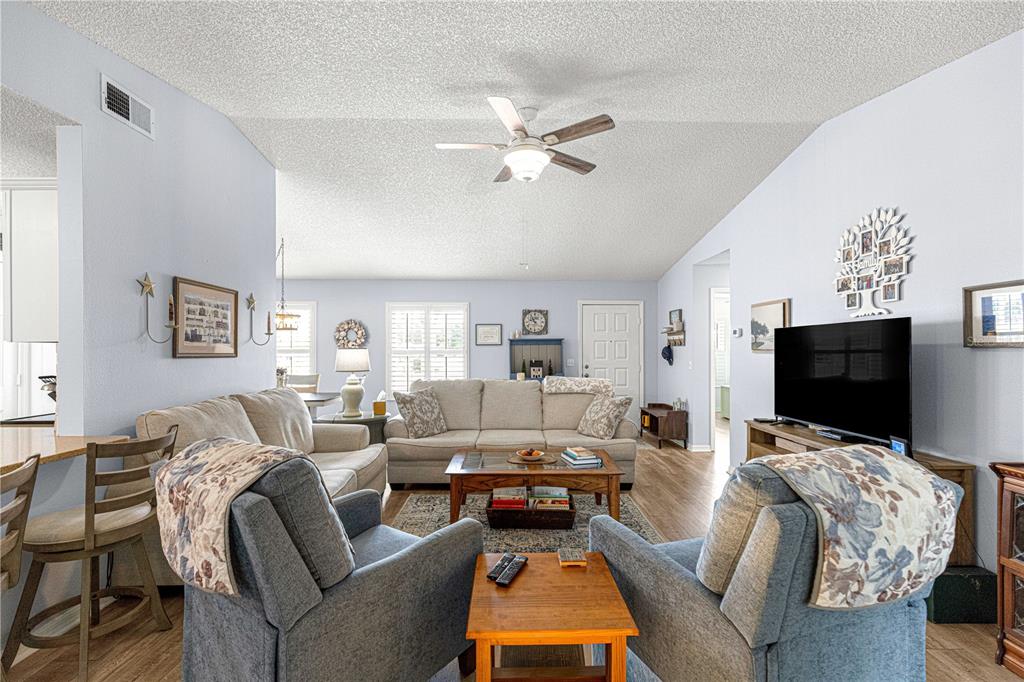 A living room features light blue walls, a vaulted ceiling, and two blue armchairs — 6091 SW 84TH PLACE ROAD, OCALA, FL