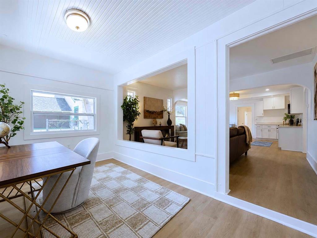 A bright room with a desk and rug overlooks an adjacent living area and kitchen — 1835 24TH STREET S, ST PETERSBURG, FL