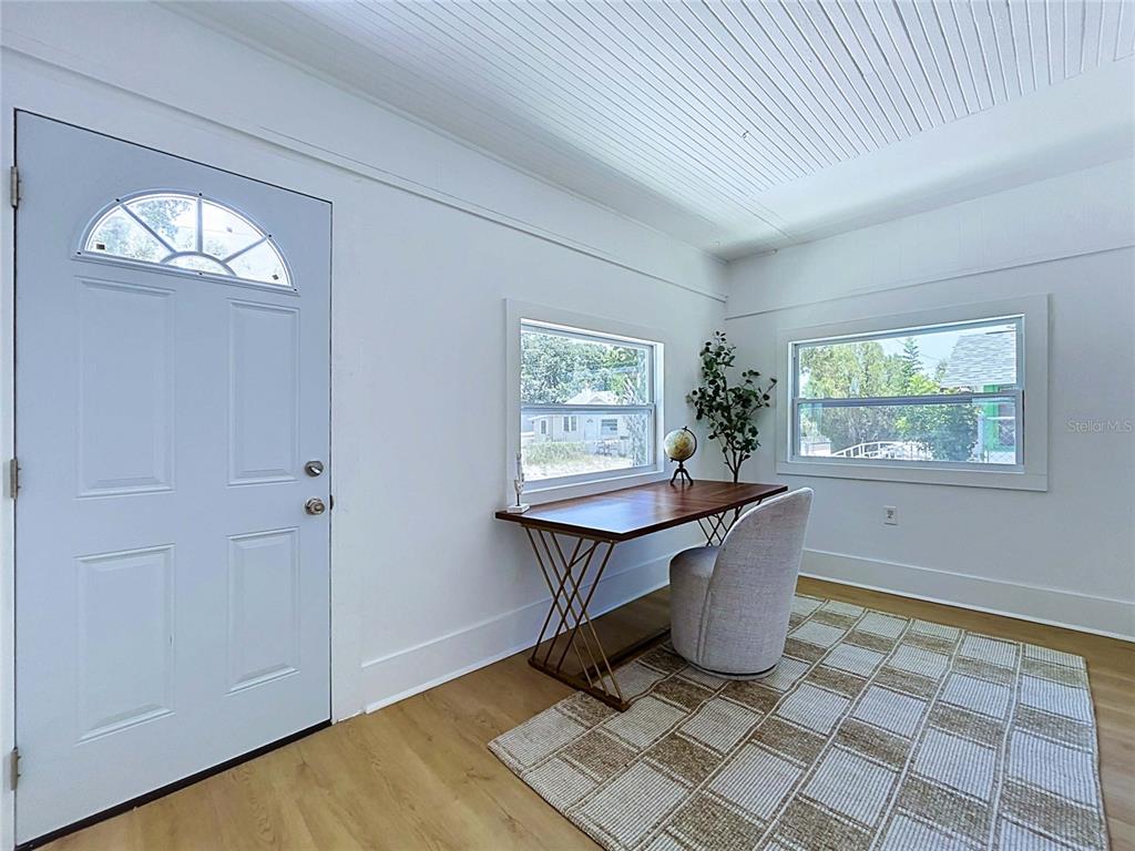 A bright room features a white door, a wooden desk, a chair, and a patterned rug — 1835 24TH STREET S, ST PETERSBURG, FL