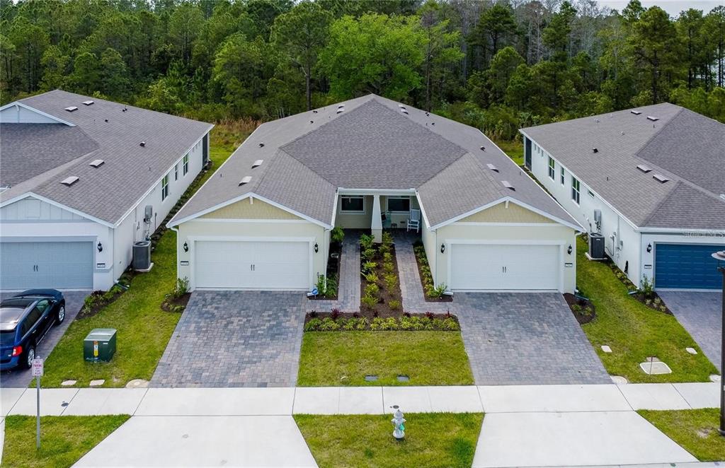 An aerial view shows a duplex home with two garages, paved driveways, and a shared entrance — 2542 CLIFF WAY, ST CLOUD, FL