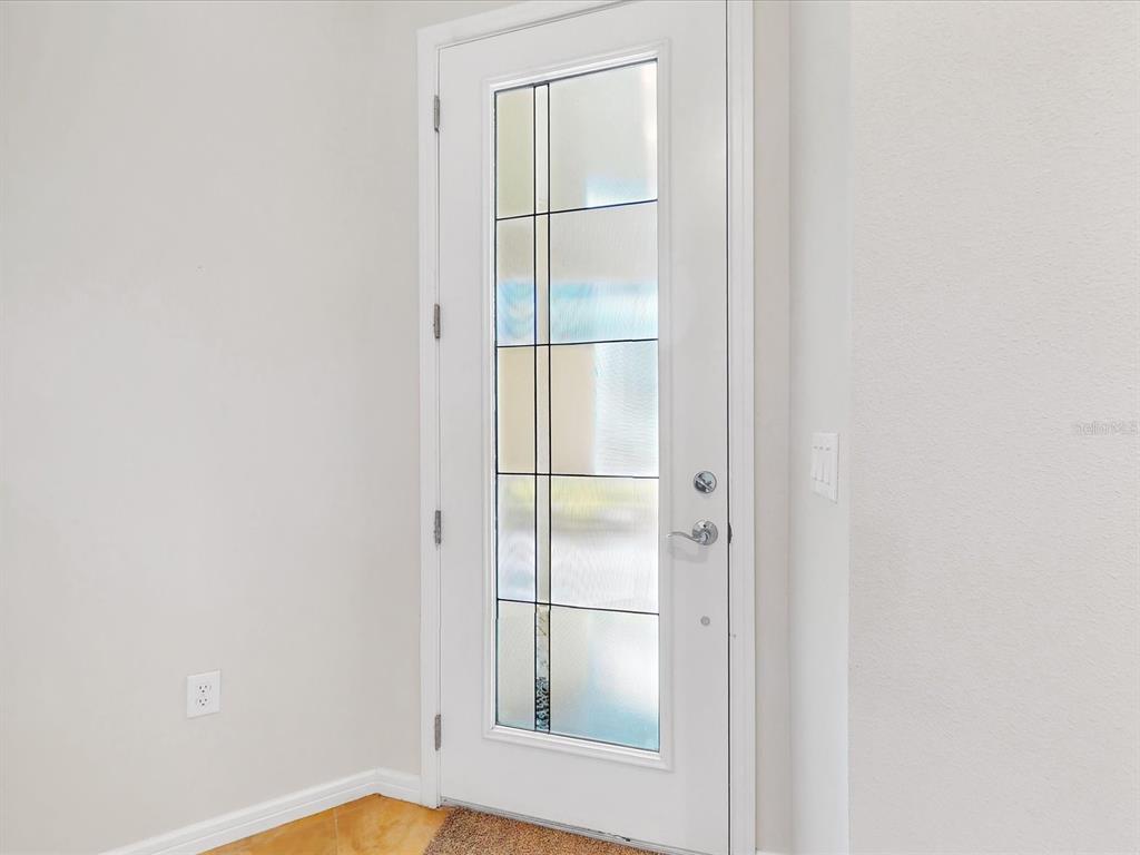 A white front door with a decorative glass panel is set against light-colored interior walls — 2542 CLIFF WAY, ST CLOUD, FL