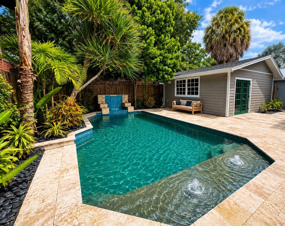 A backyard swimming pool with a fountain, stone deck, and a detached gray shed — 605 S ORLEANS AVENUE, TAMPA, FL