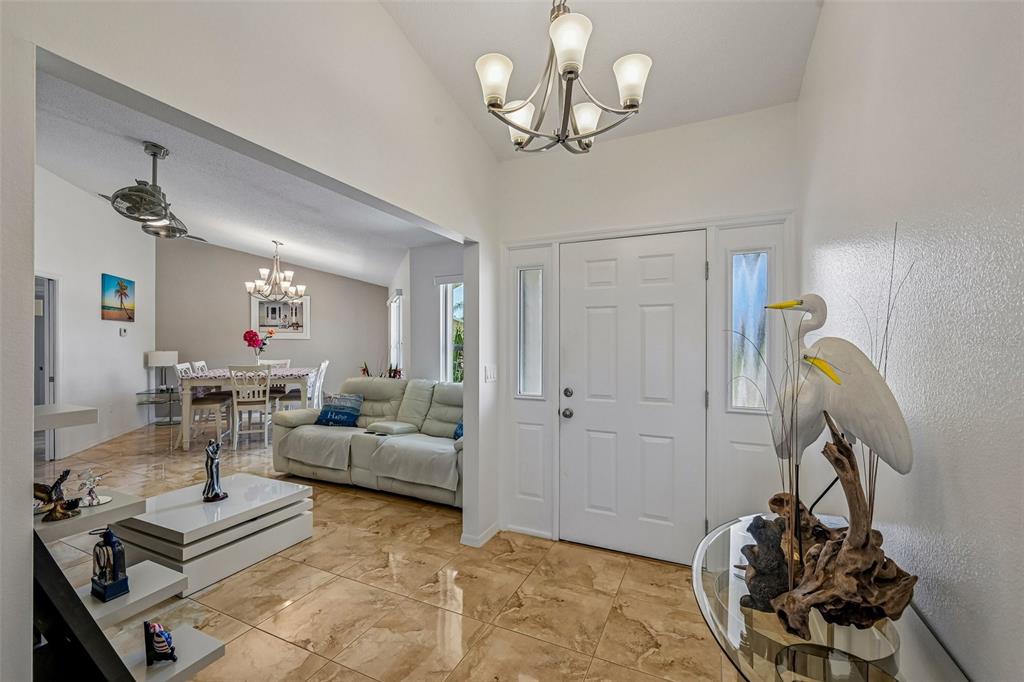 An entryway with tile flooring leads into a living room and dining area — 3072 MAUCK TERRACE, PORT CHARLOTTE, FL