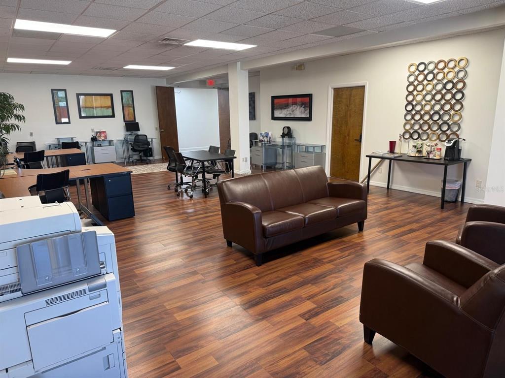An office space features a brown leather sofa, chairs, desks, and wood-look flooring — 845 N GARLAND AVENUE UNIT 220, ORLANDO, FL