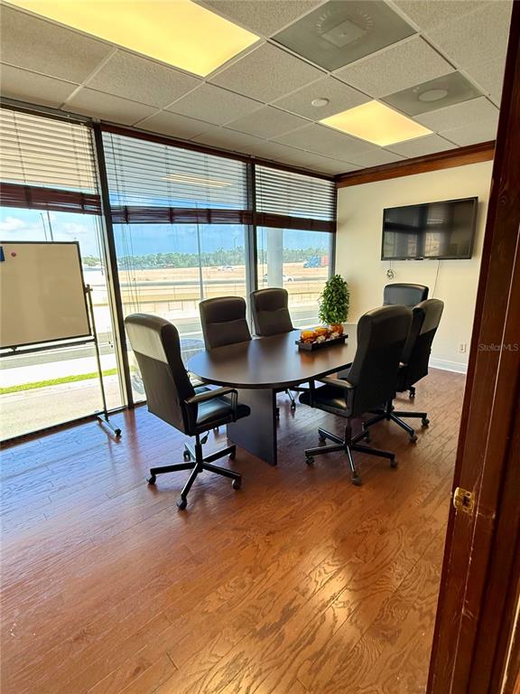 A conference room features a dark oval table, five rolling chairs, and large windows — 845 N GARLAND AVENUE UNIT 220, ORLANDO, FL
