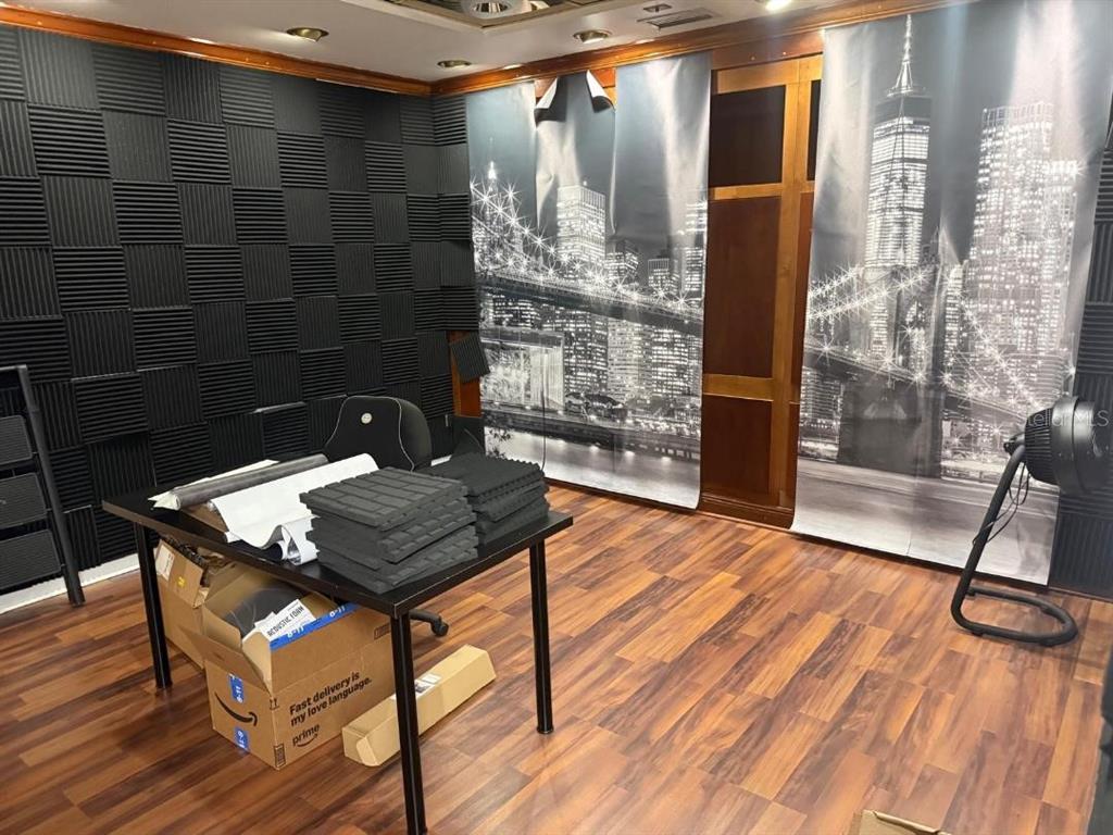 A room featuring acoustic foam wall panels, a desk with supplies, and city-themed wall tapestries — 845 N GARLAND AVENUE UNIT 220, ORLANDO, FL