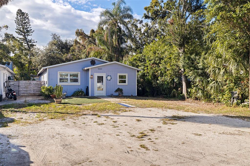A light blue single-story house sits behind a large, unpaved dirt driveway — 5322 25TH AVENUE S, GULFPORT, FL