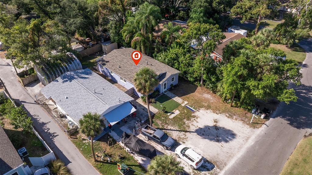 An aerial view shows two adjacent houses with shingled roofs, palm trees, and parked vehicles — 5322 25TH AVENUE S, GULFPORT, FL