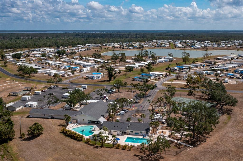 Aerial view of a mobile home community featuring two swimming pools and a clubhouse — 7412 HESTON STREET, PORT CHARLOTTE, FL