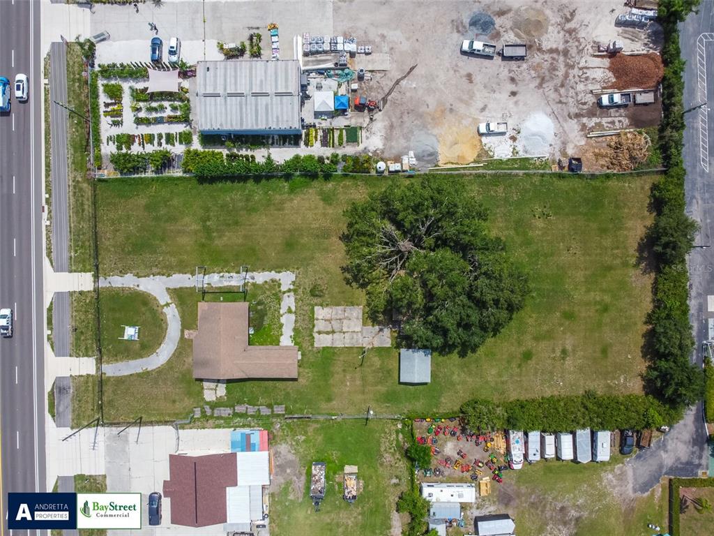 An aerial view shows a rectangular lot with a house, a large tree, and outbuildings — 34020 & 34024 STATE ROAD 54, WESLEY CHAPEL, FL