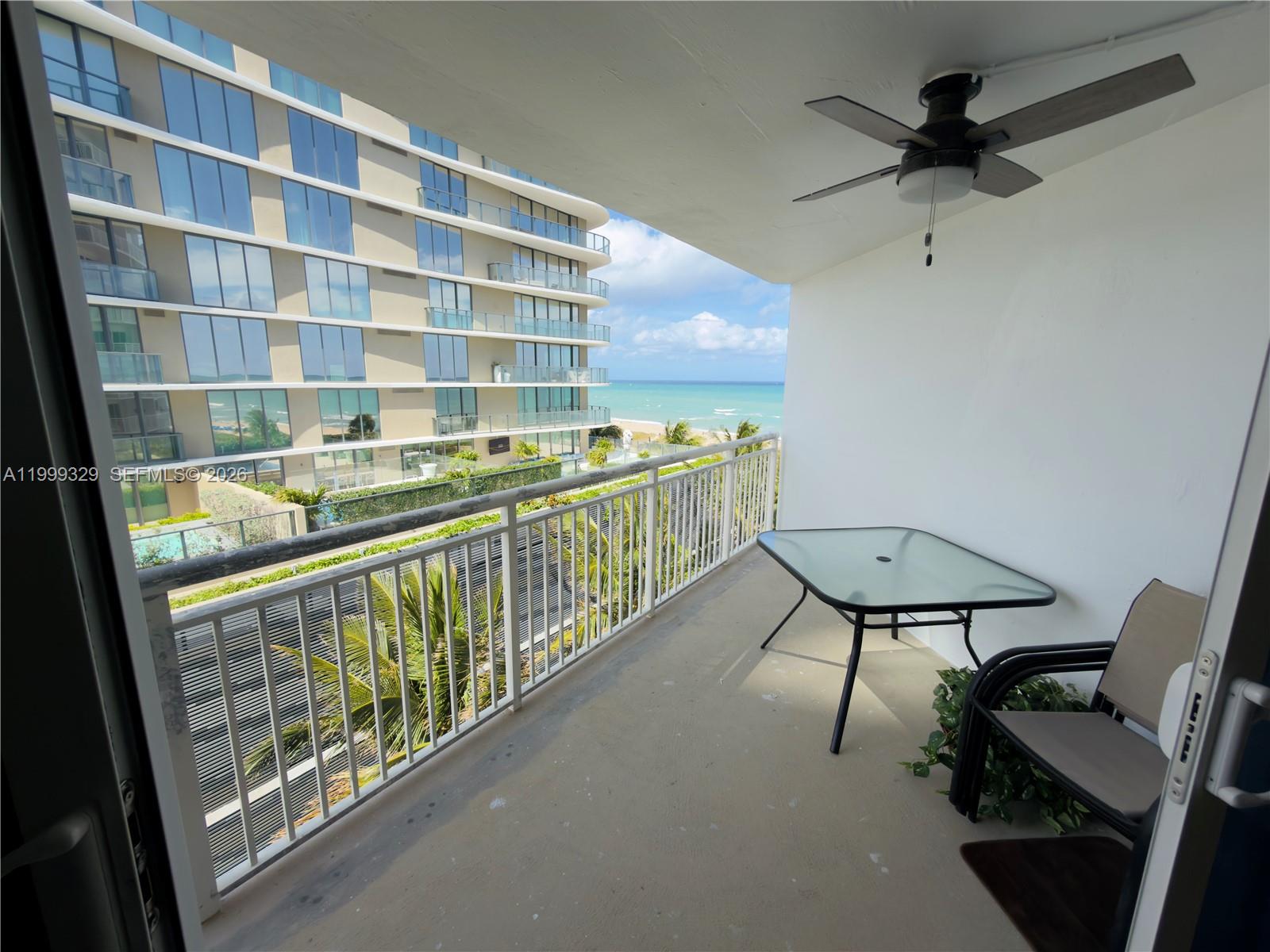 A balcony features a glass-topped table, a chair, a ceiling fan, and ocean views — 710 N Ocean Blvd # 603, Pompano Beach FL 33062, POMPANO BEACH, FL